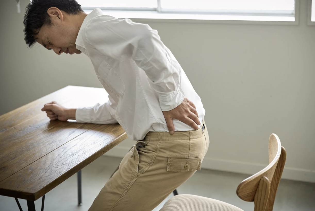 腰痛で悩まされる男性の写真
